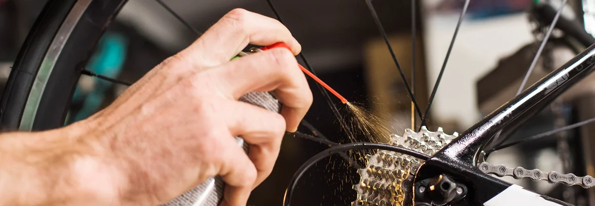 Person ölt Fahrradkette